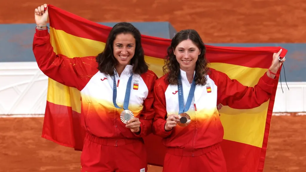 Bronze Medallists, Sara Sorribes Tormo and Cristina Bucsa of Team Spain pose with the Spanish flag on the podium during 2024 Olympics. (Matthew Stockman/Getty Images)
