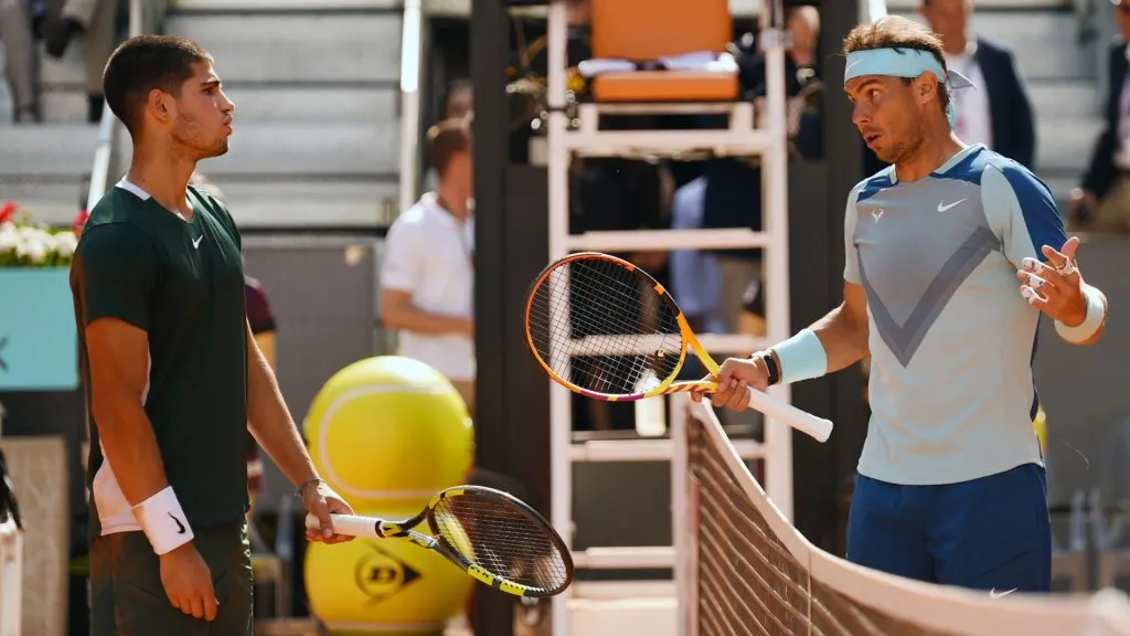 Carlos Alcaraz and Rafael Nadal interact by the net as the game is stopped during their quarter-final match during day nine of Mutua Madrid Open. (Denis Doyle/Getty Images)