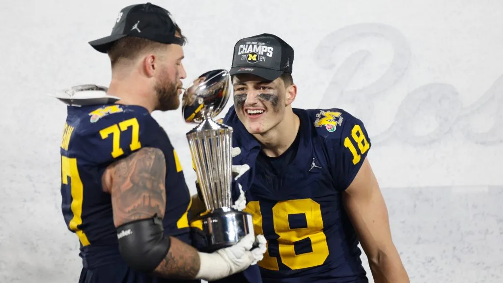 Trevor Keegan and Colston Loveland of the Michigan Wolverines celebrate with The Leishman Trophy after beating the Alabama Crimson Tide to win the CFP Semifinal Rose Bowl Game in 2024. (Source: Kevork Djansezian/Getty Images)