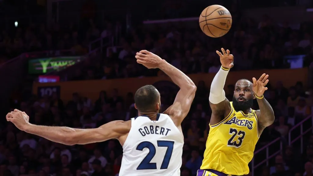 LeBron James #23 of the Los Angeles Lakers passes the ball while being guarded by Rudy Gobert #27 of the Minnesota Timberwolves