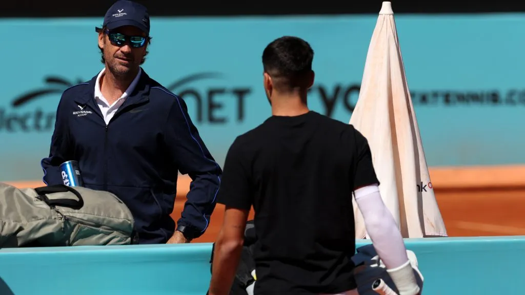 Carlos Alcaraz of Spain speaks to Rafa Nadal’s Coach, Carlos Moya during practice on Day Two of the Madrid Open. (Clive Brunskill/Getty Images)