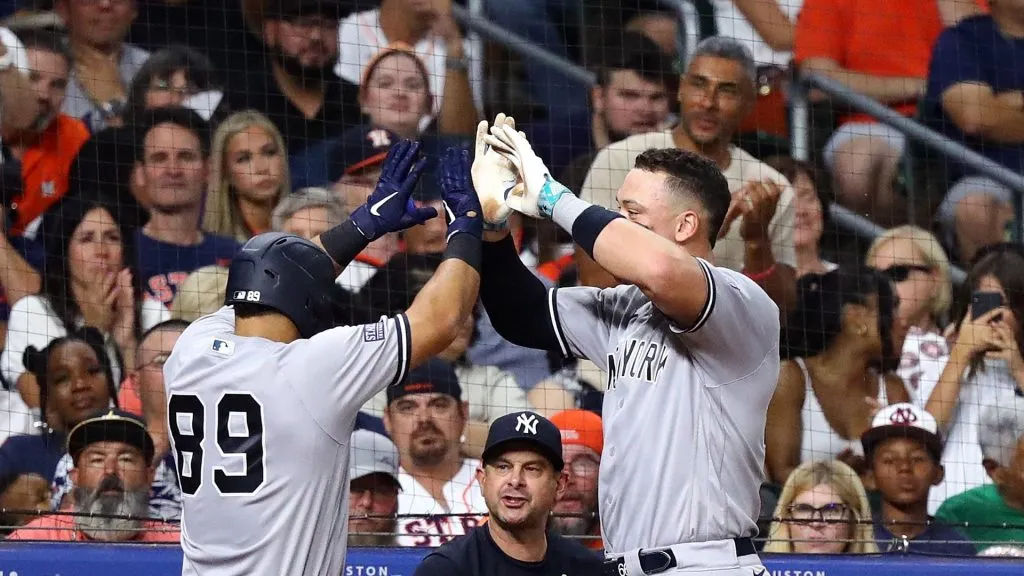 Jasson Dominguez #89 of the New York Yankees receives high fives from Aaron Judge #99 after hitting a two run home run