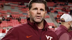 Head coach Brent Pry of the Virginia Tech Hokies talks with field judge Karina Tovar prior to the game against the North Carolina State Wolfpack at Carter-Finley Stadium on October 27, 2022 in Raleigh, North Carolina.
