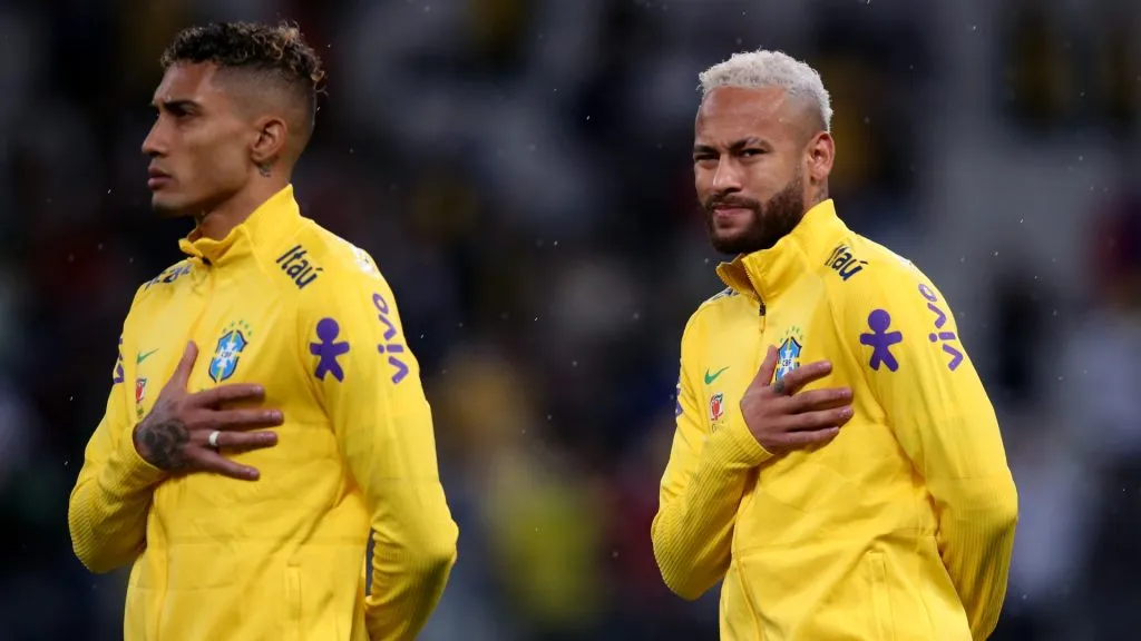Raphinha and Neymar Jr. of Brazil line up for the national anthem prior to a match between Brazil and Colombia as part of FIFA World Cup Qatar 2022 Qualifiers