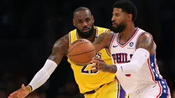 Paul George #8 of the Philadelphia 76ers passes as he is guarded by LeBron James #23 of the Los Angeles Lakers
