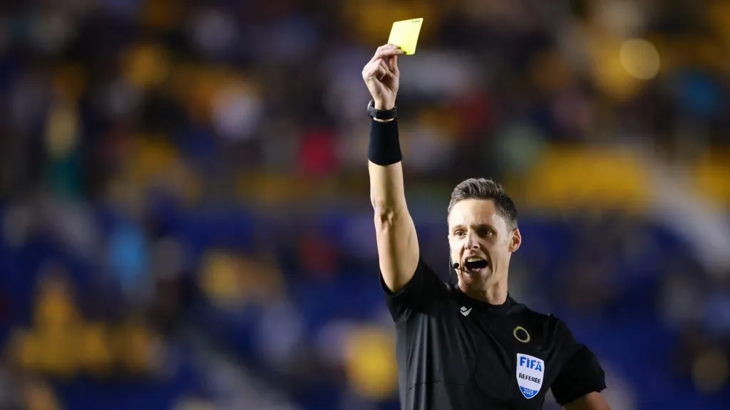 Referee Joe Dickerson shows a yellow card during a 2025 Concacaf Champions Cup match.
