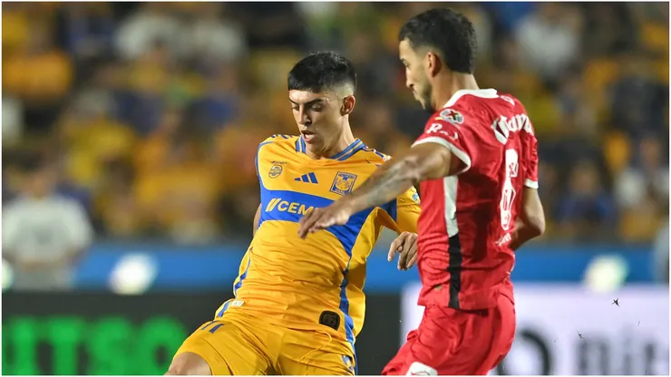 Juan Brunetta of Tigres fights for the ball with Andrés Pereira of Toluca