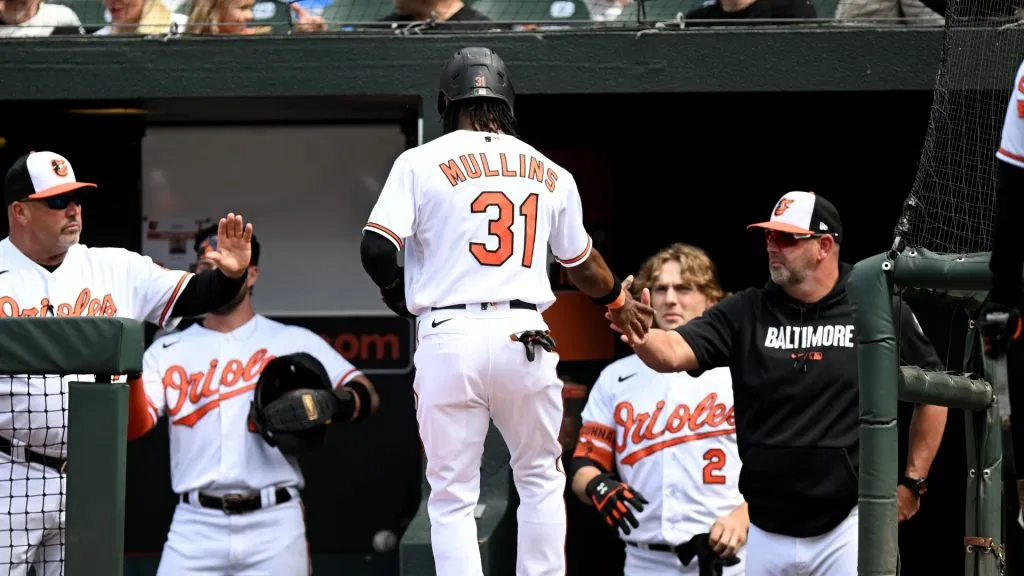 Cedric Mullins #31 of the Baltimore Orioles celebrates with manager Brandon Hyde #18 after scoring in the eighth inning against the Texas Rangers