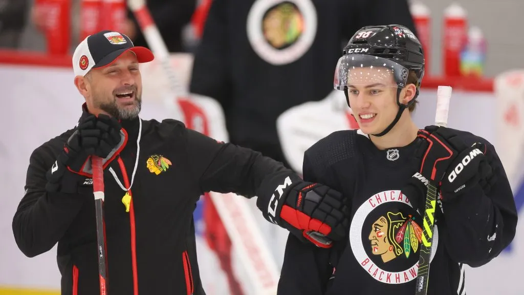 Connor Bedard #98 of the Chicago Blackhawks laughs with coach Anders Sorensen during Prospect Camp practice at Fifth Third Arena on September 14, 2023 in Chicago, Illinois.