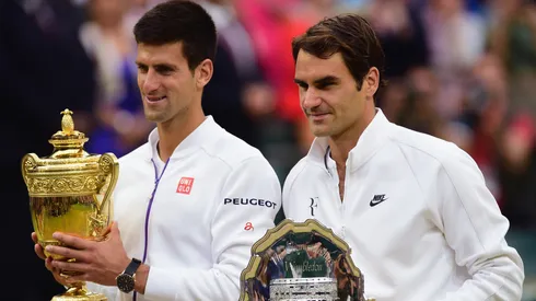 Novak Djokovic poses with the 2015 Wimbledon trophy next to Roger Federer.