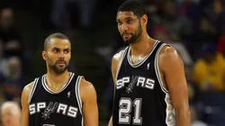 Tim Duncan #21 and Tony Parker #9 of the San Antonio Spurs stand on the court during their game against the Golden State Warriors on December 16, 2009.