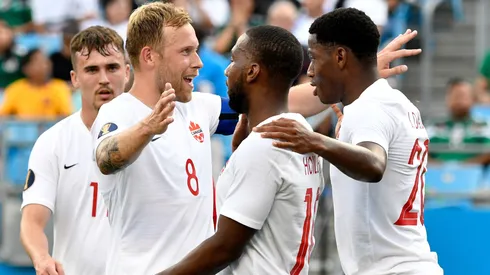 Jonathan David #20 celebrates with teammates after scoring a goal against Cuba during Canada's 7-0 win.