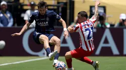 Khvicha Kvaratskhelia #7 of Paris Saint-Germain battles for possession with Javi Galan #21 of Atletico De Madrid.