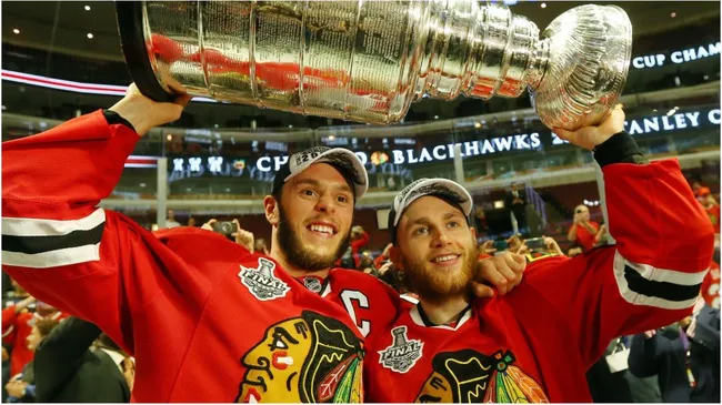 Jonathan Toews #19 and Patrick Kane #88 of the Chicago Blackhawks celebrate by hoisting the Stanley Cup after defeating the Tampa Bay Lightning in Game Six of the 2015 NHL Stanley Cup Final at the United Center on June 15, 2015 in Chicago, Illinois.