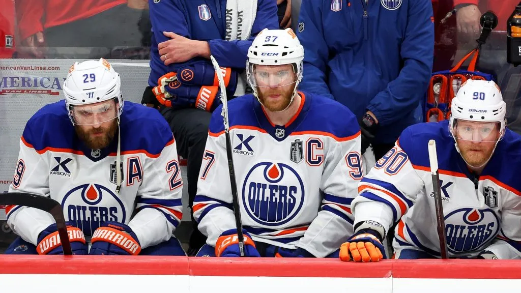 Leon Draisaitl #29, Connor McDavid #97, and Corey Perry #90 of the Edmonton Oilers react from the bench during the third period against the Florida Panthers in Game Six of the 2025 Stanley Cup Final, in Sunrise, Florida. (Photo by Mike Carlson/Getty Images)
