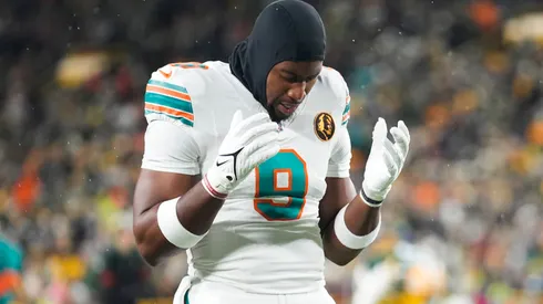 Jonnu Smith #9 of the Miami Dolphins kneels on the field prior to a game against the Green Bay Packers at Lambeau Field on November 28, 2024 in Green Bay, Wisconsin.
