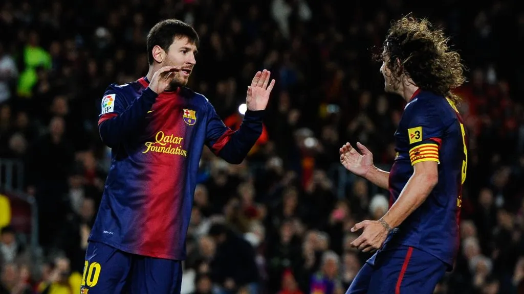 Lionel Messi celebrates with Carles Puyol after scoring a goal during a match between Barcelona CA Osasuna in 2013