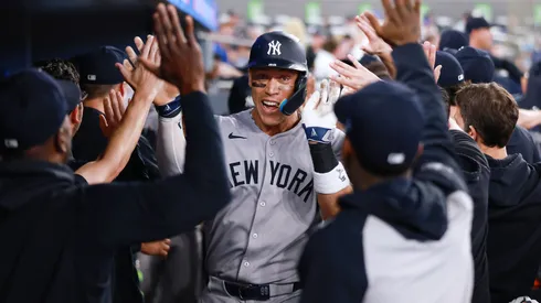 Aaron Judge #99 of the New York Yankees celebrates in the dugout after hitting a 2 run home run in the eighth inning during a game against the Toronto Blue Jays at Rogers Centre on July 02, 2025 in Toronto, Ontario, Canada.