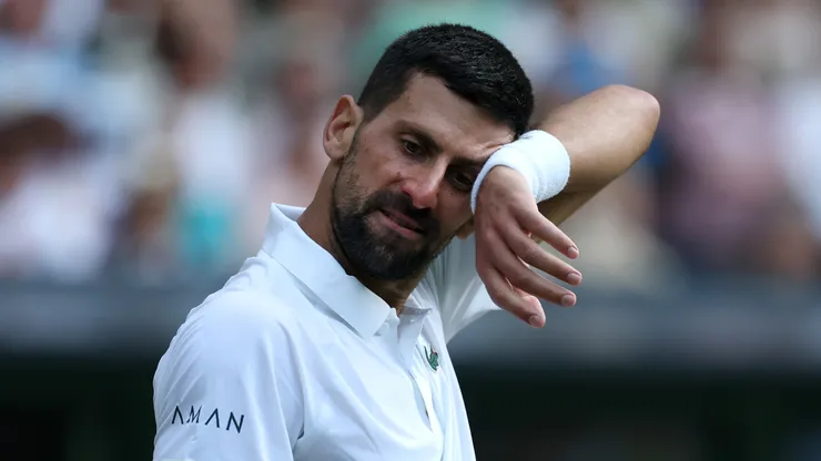 Novak Djokovic of Serbia wipes his forehead as he reacts against Flavio Cobolli of Italy during the Gentlemen's Singles quarter-final match on day ten of The Championships Wimbledon 2025
