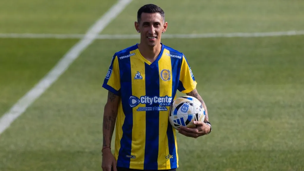 Ángel Di María poses for pictures holding a ball and wearing his Rosario Central jersey during his unveiling as new player of Rosario Central