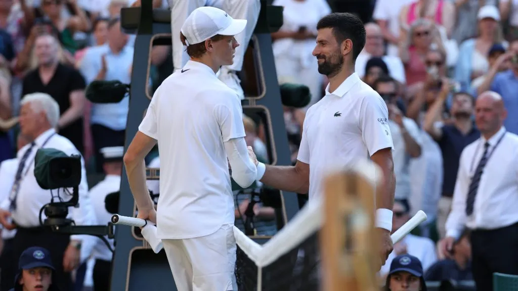 Jannik Sinner of Italy embraces Novak Djokovic of Serbia at the net following his victory during the Wimbledon semifinal. (Clive Brunskill/Getty Images)