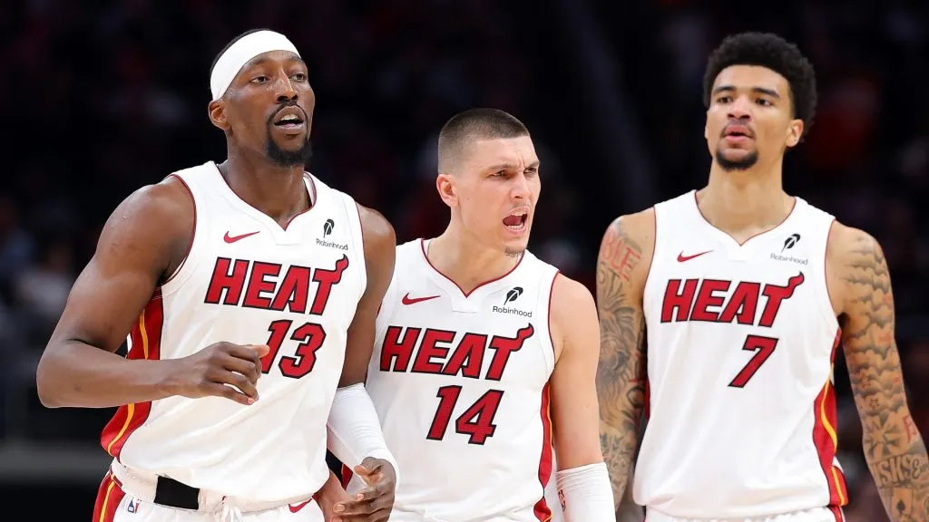Bam Adebayo #13, Tyler Herro #14 and Kel'el Ware #7 of the Miami Heat react against the Atlanta Hawks during the third quarter of an NBA play-in tournament game on April 18, 2025 in Atlanta, Georgia.