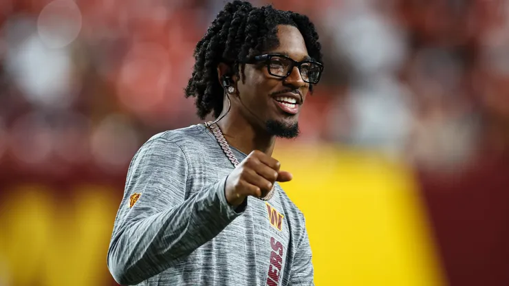 Jayden Daniels #5 of the Washington Commanders reacts in street clothes in the second quarter of a preseason game against the New England Patriots at Commanders Field on August 25, 2024 in Landover, Maryland.