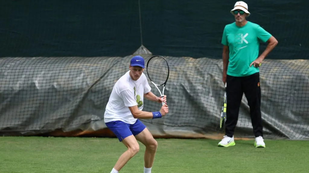 Jannik Sinner hits a backhand next to his coach Darren Cahill during a practice session prior to The Championships Wimbledon 2025