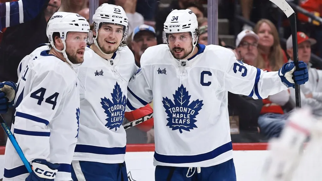 : Auston Matthews #34 of the Toronto Maple Leafs, right, celebrates a goal against the Florida Panthers with teammates Morgan Rielly #44 and Matthew Knies #23 of the Toronto Maple Leafs during the third period in Game Six of the Second Round of the 2025 Stanley Cup Playoffs at Amerant Bank Arena on May 16, 2025 in Sunrise, Florida. (Photo by Carmen Mandato/Getty Images)