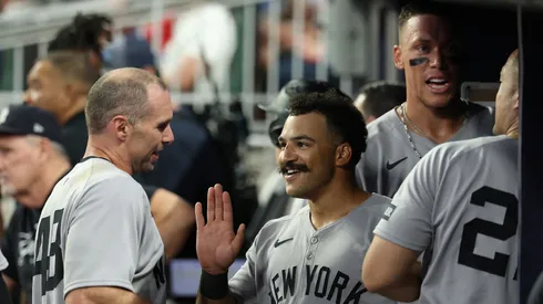 Trent Grisham #12 of the New York Yankees reacts with Paul Goldschmidt #48 after hitting a grand slam in the ninth inning against the Atlanta Braves at Truist Park on July 19, 2025 in Atlanta, Georgia.