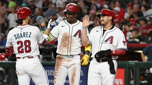 Eugenio Suarez #28 of the Arizona Diamondbacks celebrates with Geraldo Perdomo #2 and Josh Naylor #22 after hitting a three run home run.