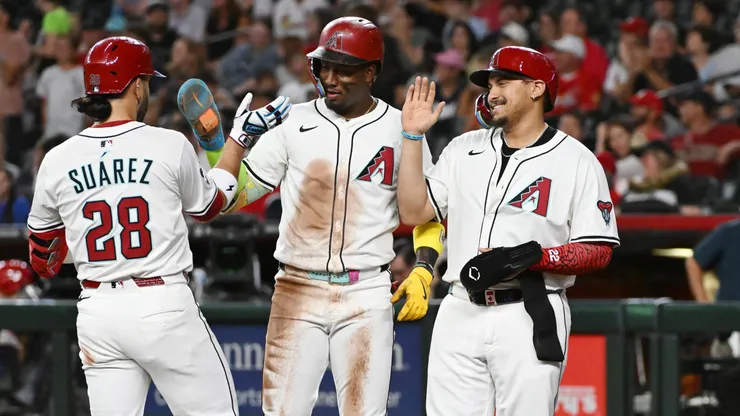 Eugenio Suarez #28 of the Arizona Diamondbacks celebrates with Geraldo Perdomo #2 and Josh Naylor #22 after hitting a three run home run.