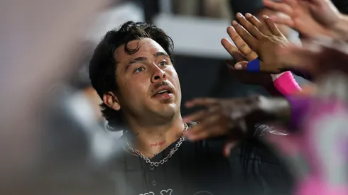 Francisco Alvarez #4 of the New York Mets high fives teammates in the dugout.