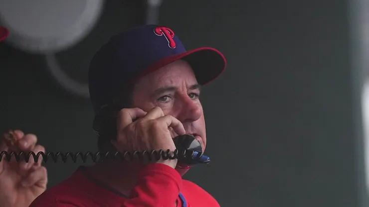 Rob Thomson #59 of the Philadelphia Phillies talks on the phone during a delay in the game against the Los Angeles Angels at Citizens Bank Park on July 20, 2025 in Philadelphia, Pennsylvania.