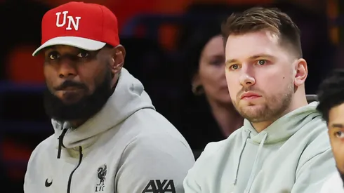 Luka Doncic #77 and LeBron James #23 of the Los Angeles Lakers look on from the bench during the third quarter at Crypto.com Arena.