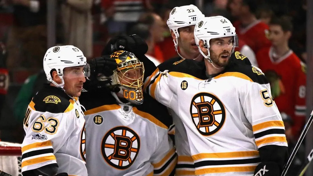 Brad Marchand #63, Anton Khudobin #35, Adam McQuaid #54 and Zdeno Chara #33 of the Boston Bruins celebrate a win over the Chicago Blackhawks at the United Center on April 2, 2017 in Chicago, Illinois.