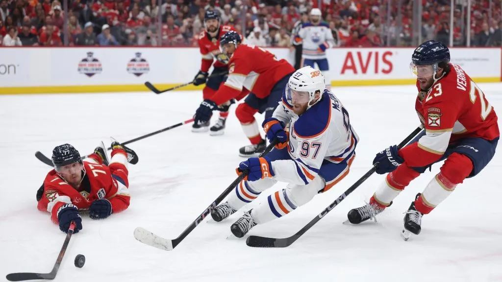 Connor McDavid #97 of the Edmonton Oilers attempts a shot under pressure from Carter Verhaeghe #23 and Niko Mikkola #77 of the Florida Panthers in Game Six of the 2025 Stanley Cup Finals at Amerant Bank Arena on June 17, 2025 in Sunrise, Florida. (Photo by Christian Petersen/Getty Images)