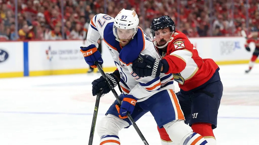 Connor McDavid #97 of the Edmonton Oilers skates with the puck against Brad Marchand #63 of the Florida Panthers