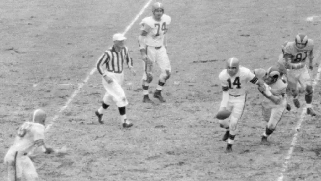 Otto Graham eluding tackles. (Source: Getty Images)