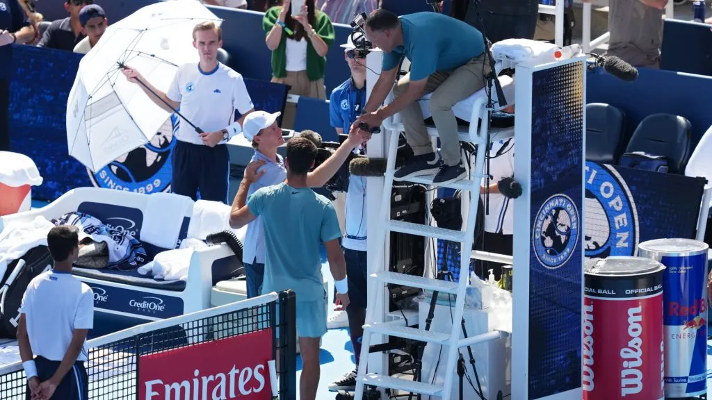 Jannik Sinner of Italy meets with Carlos Alcaraz of Spain and umpire Mohamed Lahyani to retire from the Cincinnati Open final. (Dylan Buell/Getty Images)