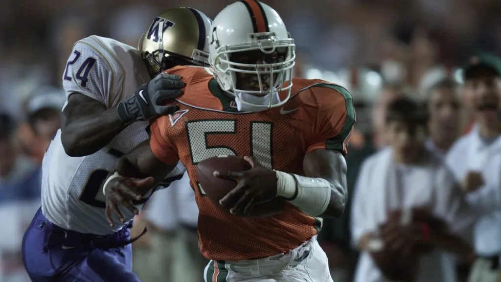 Jonathan Vilma # 51 of the Miami Hurricanes makes an interception with tailback Rich Alexis #24 of the Washington Huskies in tow during the first quarter of the game in 2001. (Source: Eliot Schechter/Getty Images)