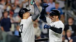 Austin Wells #28 of the New York Yankees is congratulated by teammate Giancarlo Stanton #27.