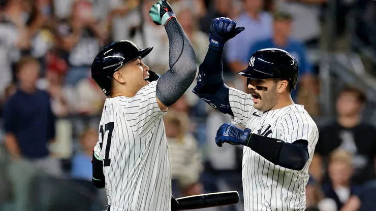 Austin Wells #28 of the New York Yankees is congratulated by teammate Giancarlo Stanton #27.