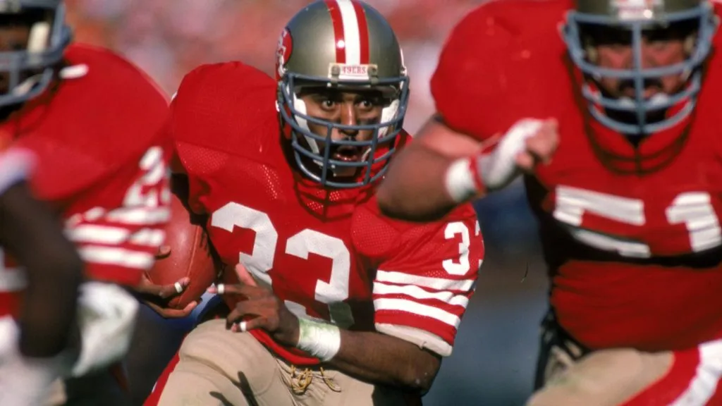 Roger Craig #33 of the San Francisco 49ers follows his lead blocker offensive guard Randy Cross #51 against the Buccaneers in 1984. (Source: George Rose/Getty Images)