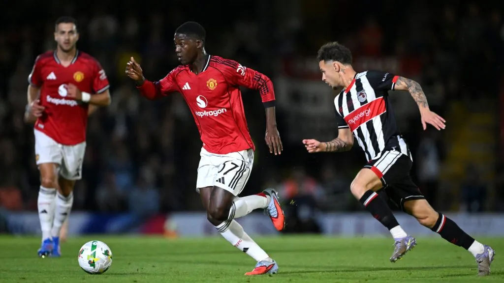 Kobbie Mainoo of Manchester United runs with the ball whilst under pressure from George McEachran of Grimsby Town. (Shaun Botterill/Getty Images)
