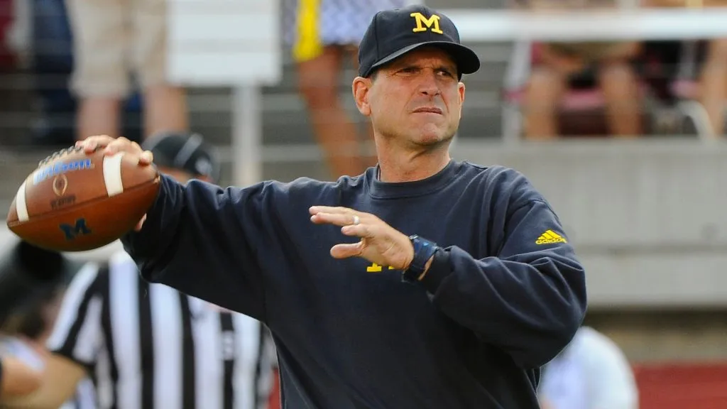 Jim Harbaugh of the Michigan Wolverines warms up his quarterbacks before their game against the Utah Utes in 2015. (Source: Gene Sweeney Jr/Getty Images)