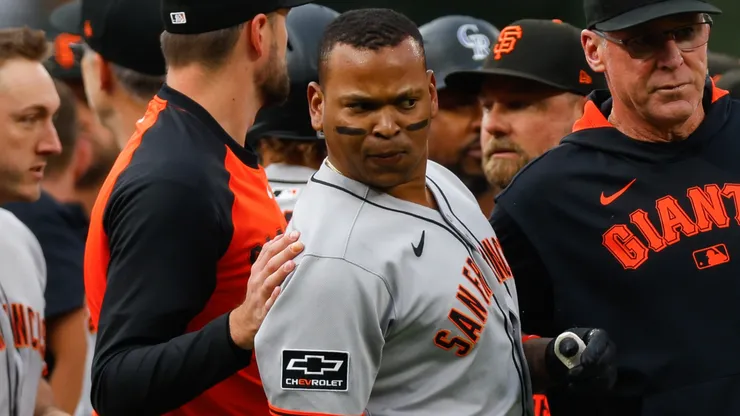 Rafael Devers #16 and Manager Bob Melvin of the San Francisco Giants stand on the field.