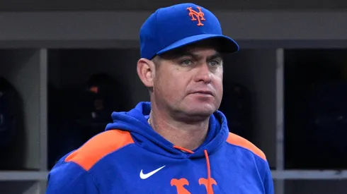 Manager Carlos Mendoza #64 of the New York Mets looks on from the dugout.