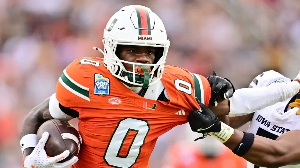 Joshisa Trader #0 of the Miami Hurricanes stiff arms Myles Purchase #5 of the Iowa State Cyclones.