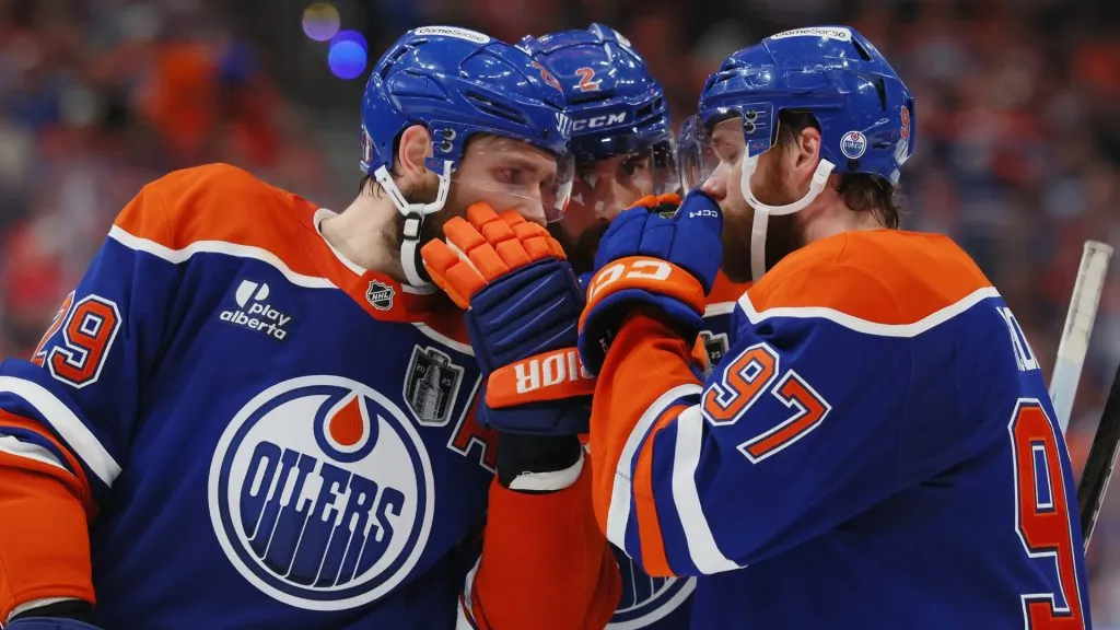 Leon Draisaitl #29, Evan Bouchard #2 and Connor McDavid #97 of the Edmonton Oilers confer during a game. (Photo by Bruce Bennett/Getty Images)